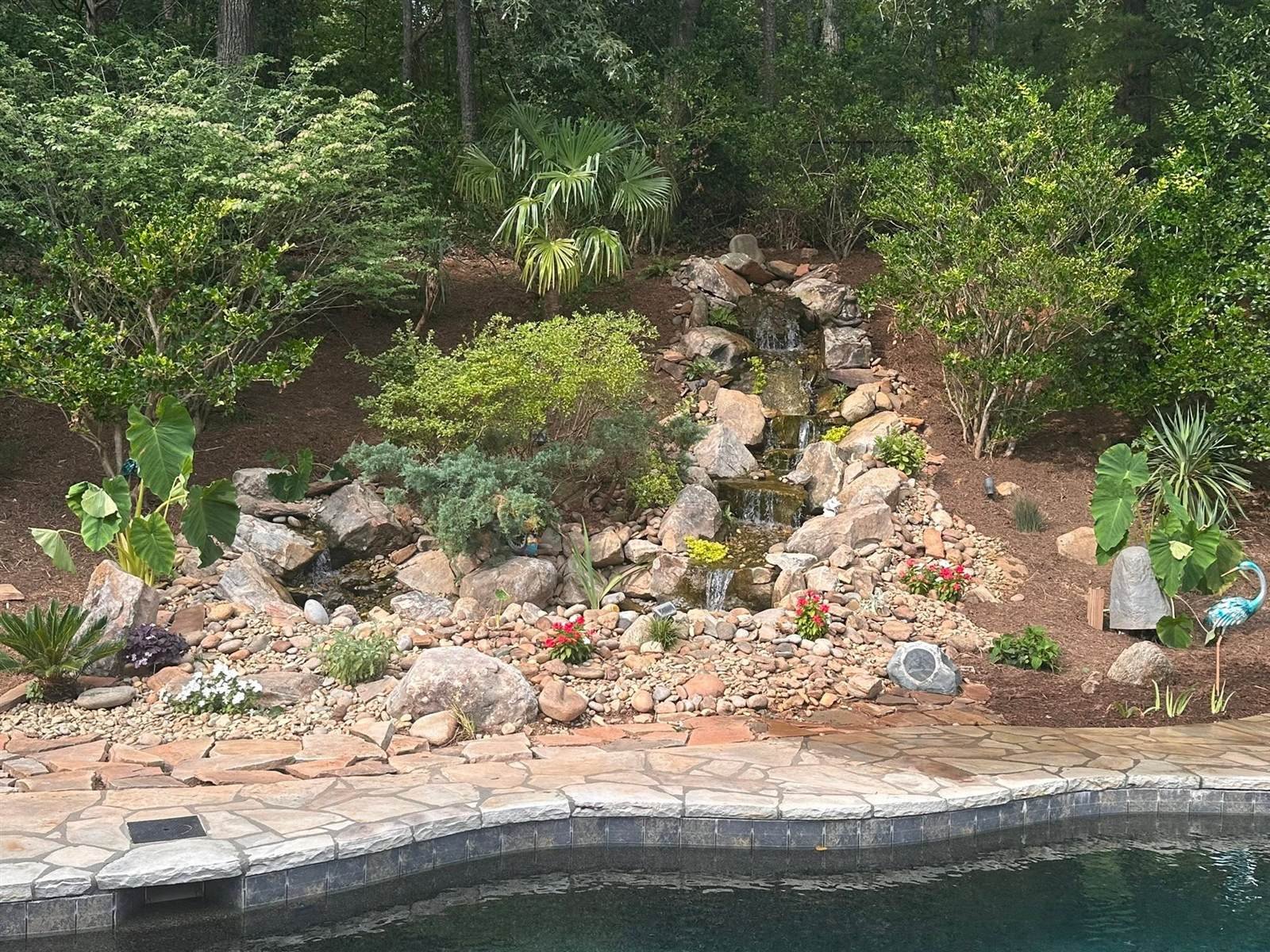Finished stone outdoor fireplace and brick pizza oven with mountain view