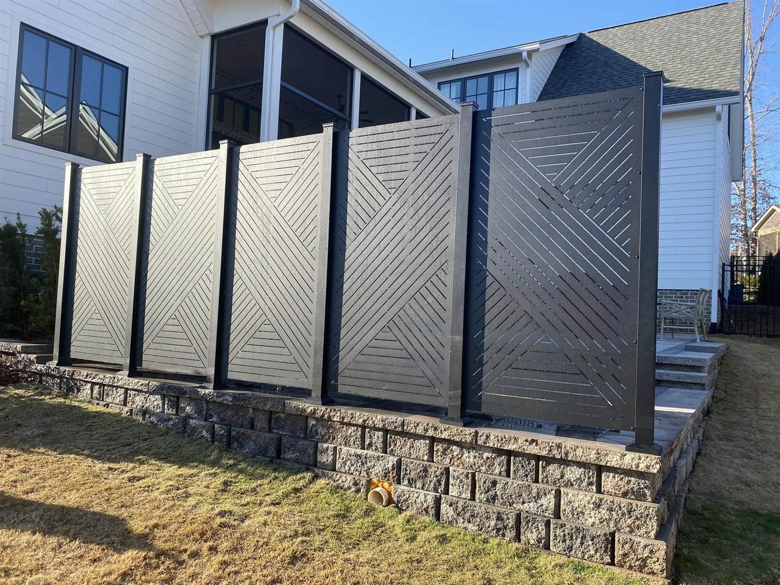 Modern geometric privacy screen panels on a paver patio