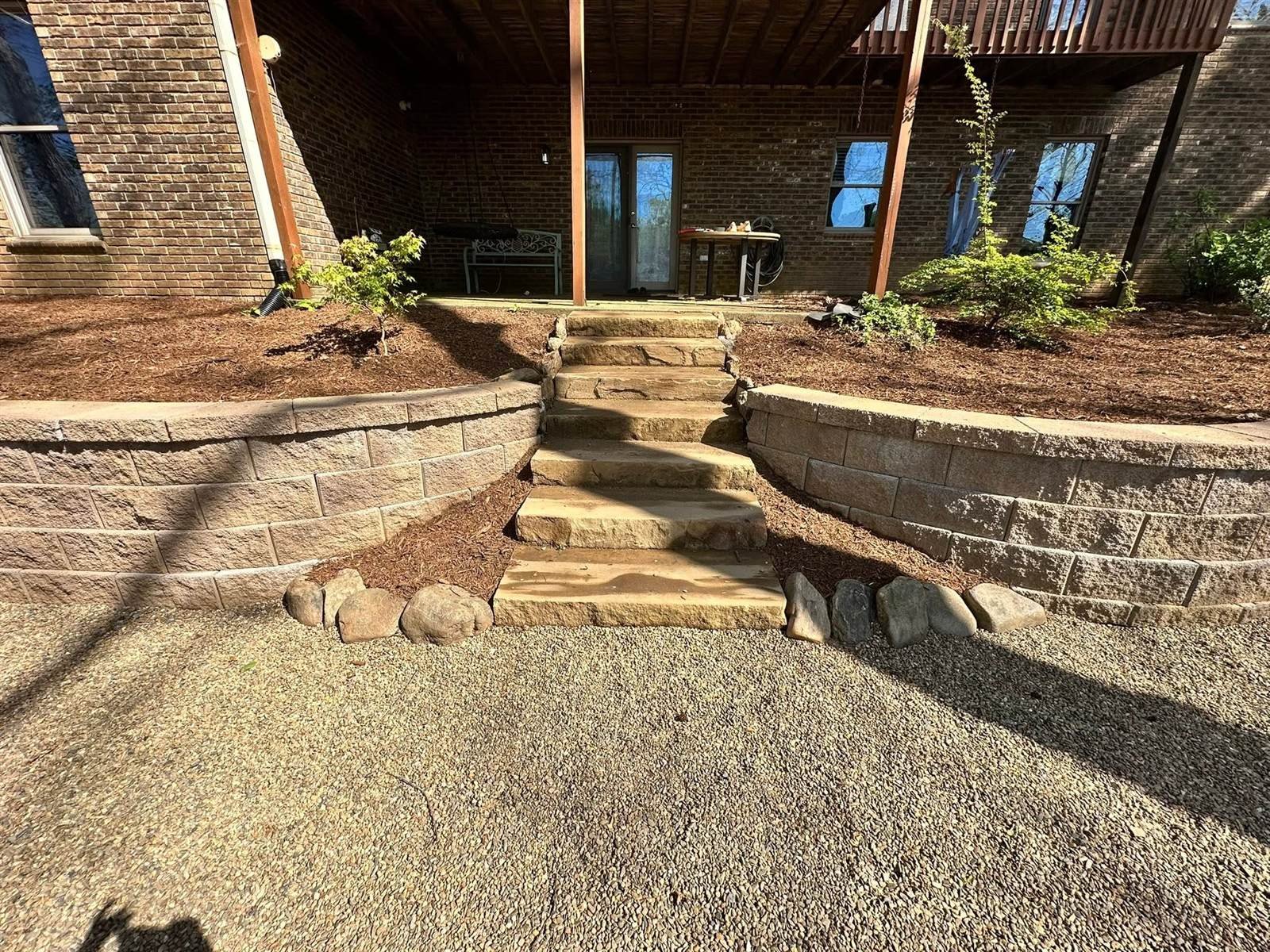 Natural sandstone steps leading to a stone retaining wall patio